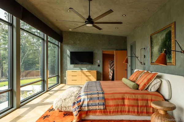 a bedroom with a large bed and a flat tv screen