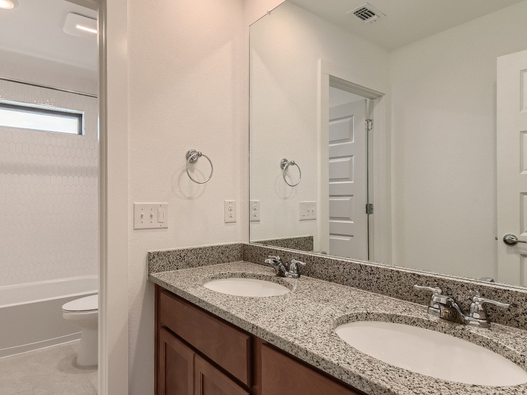 9101 Spire View Austin, TX 78744 - Photo 21 of 29 a bathroom with a granite countertop sink and a mirror