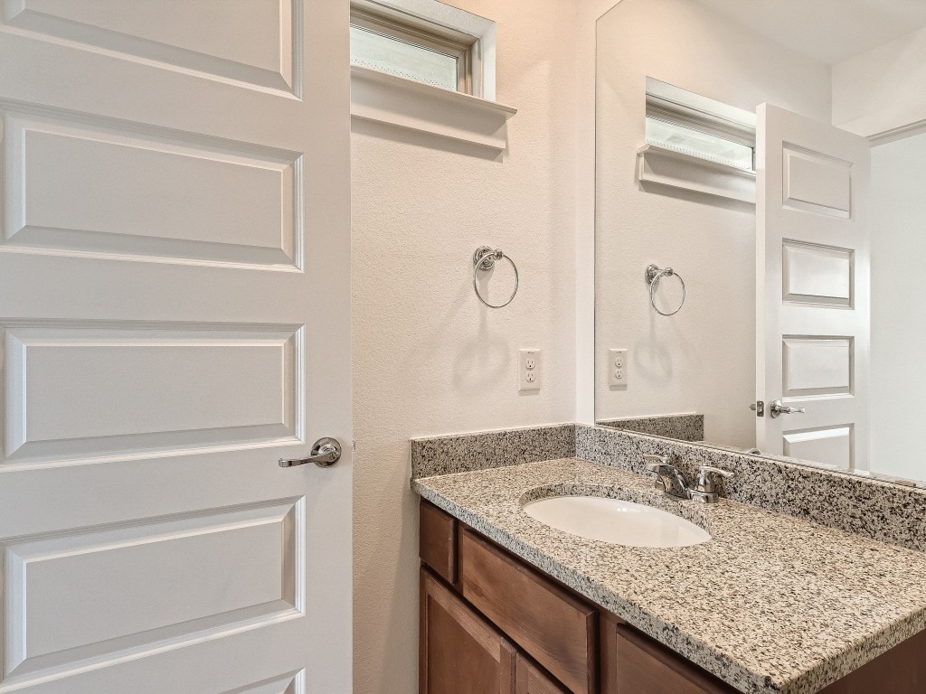 9101 Spire View Austin, TX 78744 - Photo 23 of 29 a bathroom with a granite countertop sink and a mirror
