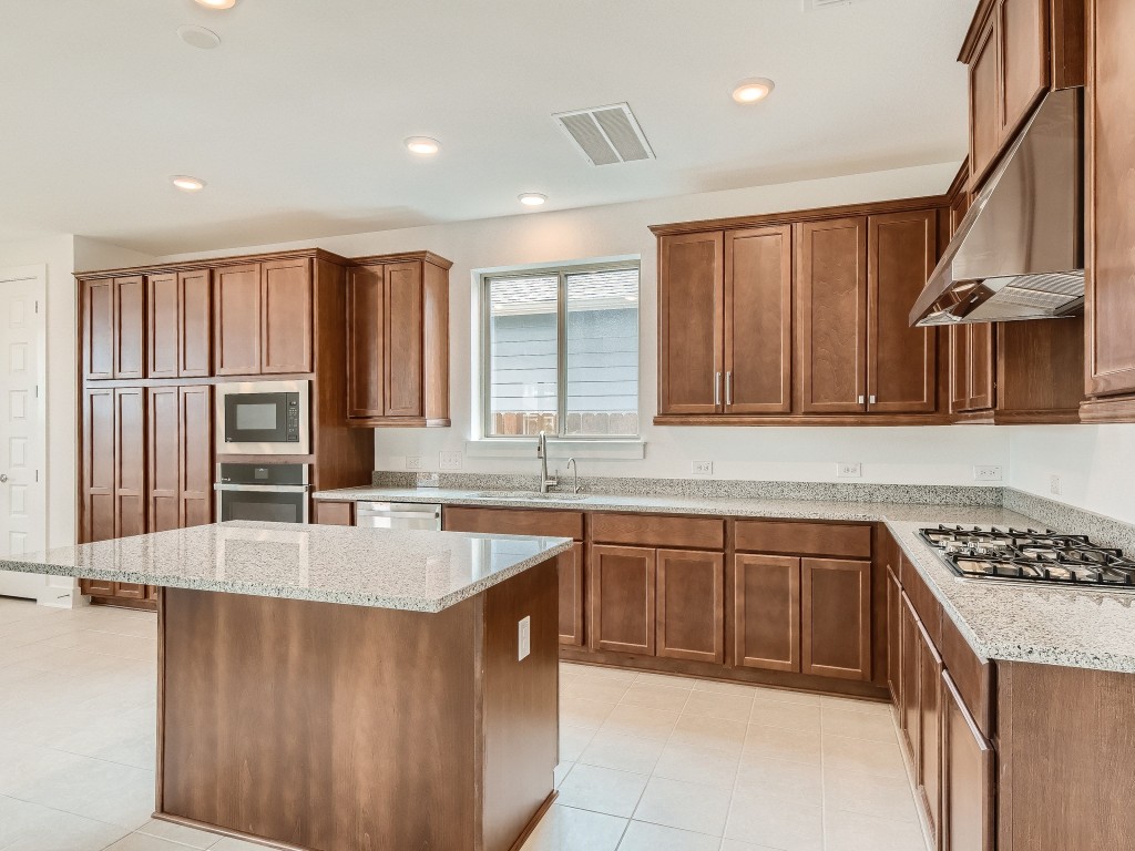 9101 Spire View Austin, TX 78744 - Photo 10 of 29 a kitchen with stainless steel appliances granite countertop a sink stove and refrigerator