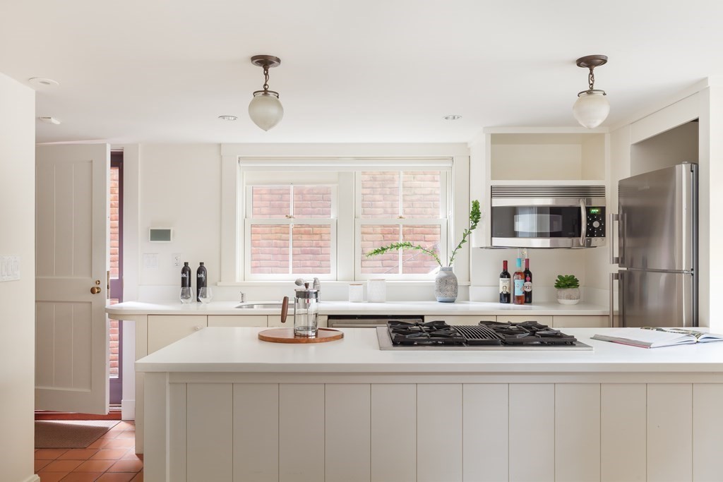 11 Hemlock Road Cambridge, MA 02138 - Photo 31 of 35 a kitchen with kitchen island granite countertop a sink appliances a counter top space and cabinets