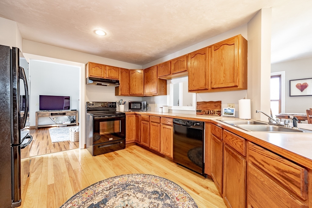 162 Chestnut Plain Road Whately, MA 01093 - Photo 18 of 42 a kitchen with stainless steel appliances kitchen island granite countertop a stove top oven a sink dishwasher a dining table and chairs with wooden floor
