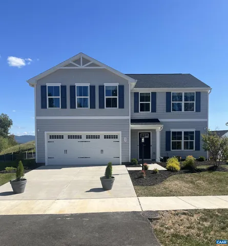 a front view of a house with yard and parking