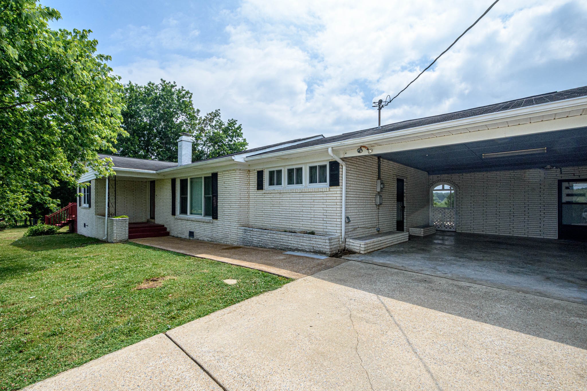 a front view of a house with a garden and trees
