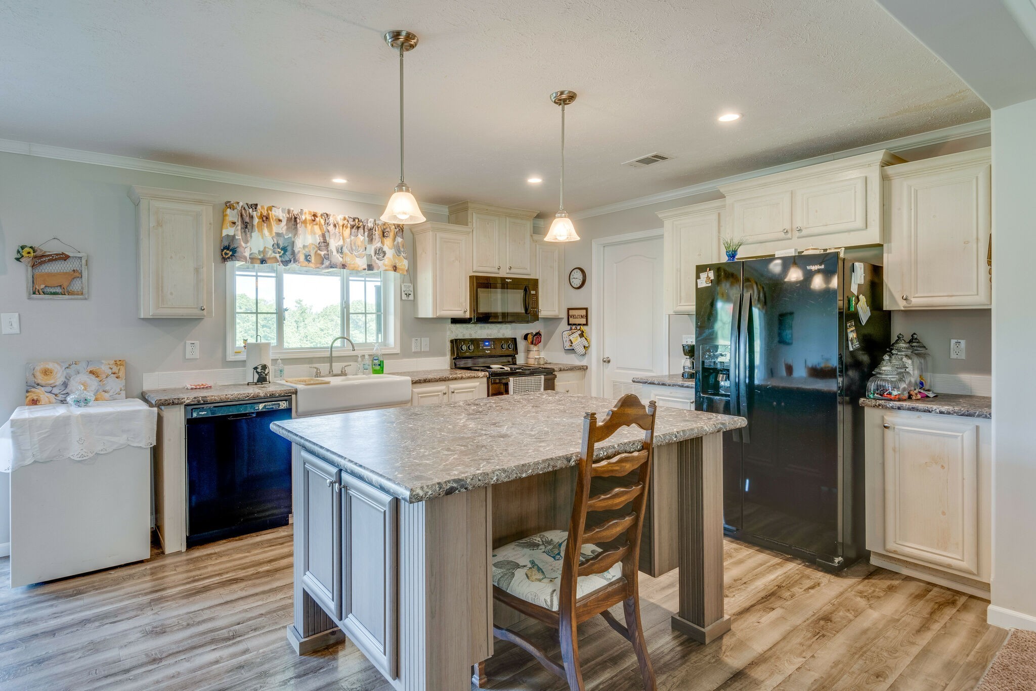 4585 West Tennessee City Road McEwen, TN 37101 - Photo 24 of 55 a kitchen with kitchen island granite countertop a table chairs refrigerator and microwave
