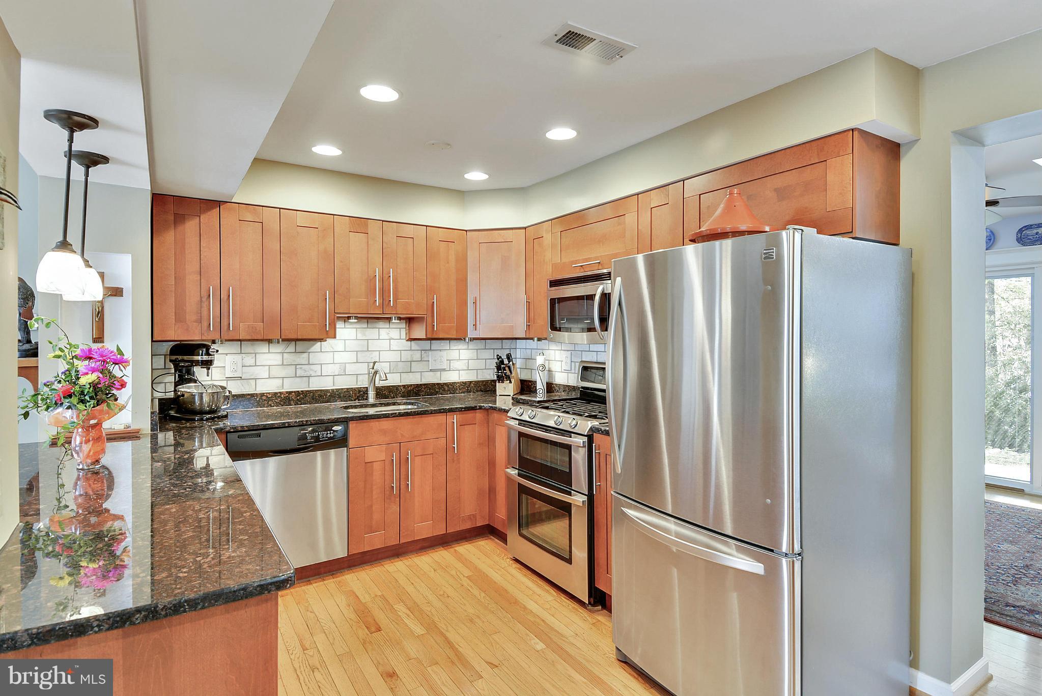 1021 Carson Street Silver Spring, MD 20901 - Photo 14 of 26 a kitchen with granite countertop stainless steel appliances a refrigerator a sink and cabinets