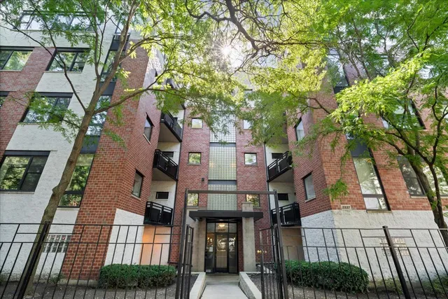 front view of a brick house with large trees