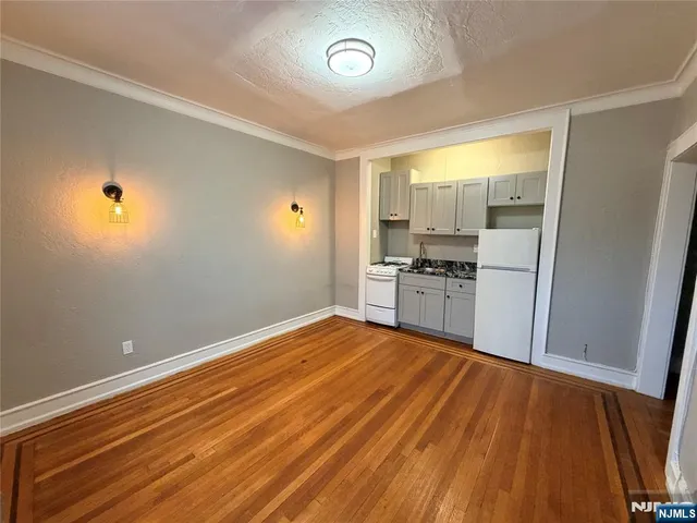 a kitchen with stainless steel appliances granite countertop a refrigerator stove and white cabinets