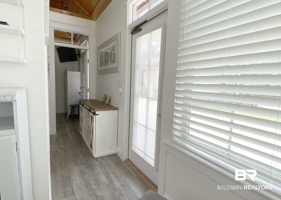28888 Canal Road, Unit 77 Orange Beach, AL 36561 - Photo 5 of 23 Bright interior featuring light wood-finish flooring, a vaulted wood-paneled ceiling, and a glass-paneled door