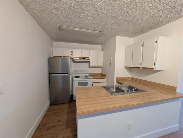 a kitchen with kitchen island a refrigerator a stove a microwave and cabinets