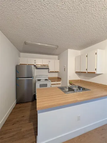 a kitchen with stainless steel appliances granite countertop a refrigerator and a stove top oven