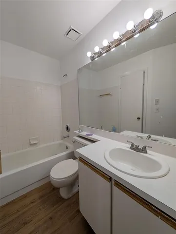 a bathroom with a sink a toilet a mirror and bathtub