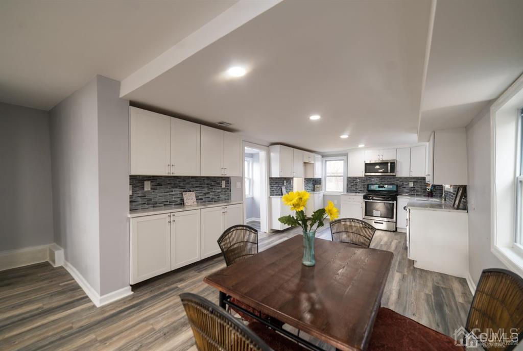 8 Main Street Matawan, NJ 07747 - Photo 11 of 36 a kitchen with stainless steel appliances granite countertop a stove white cabinets a sink dishwasher and white cabinets with wooden floor