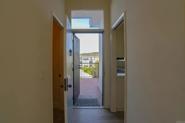 a view of a hallway with wooden floor and a bathroom