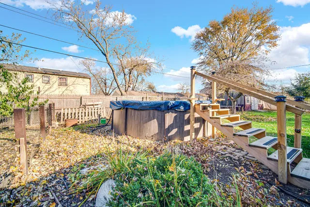 a view of a patio with table and chairs and floor to ceiling window with wooden fence