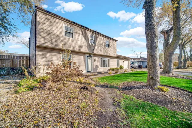 a view of a house with backyard and a tree