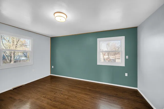 wooden floor in an empty room with a window