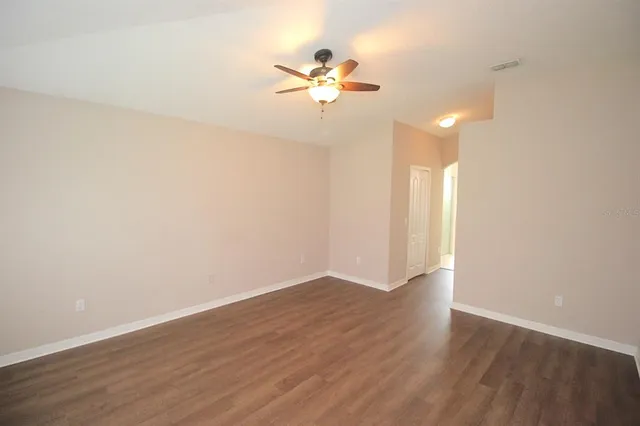 a view of a hallway with a large window and a kitchen space