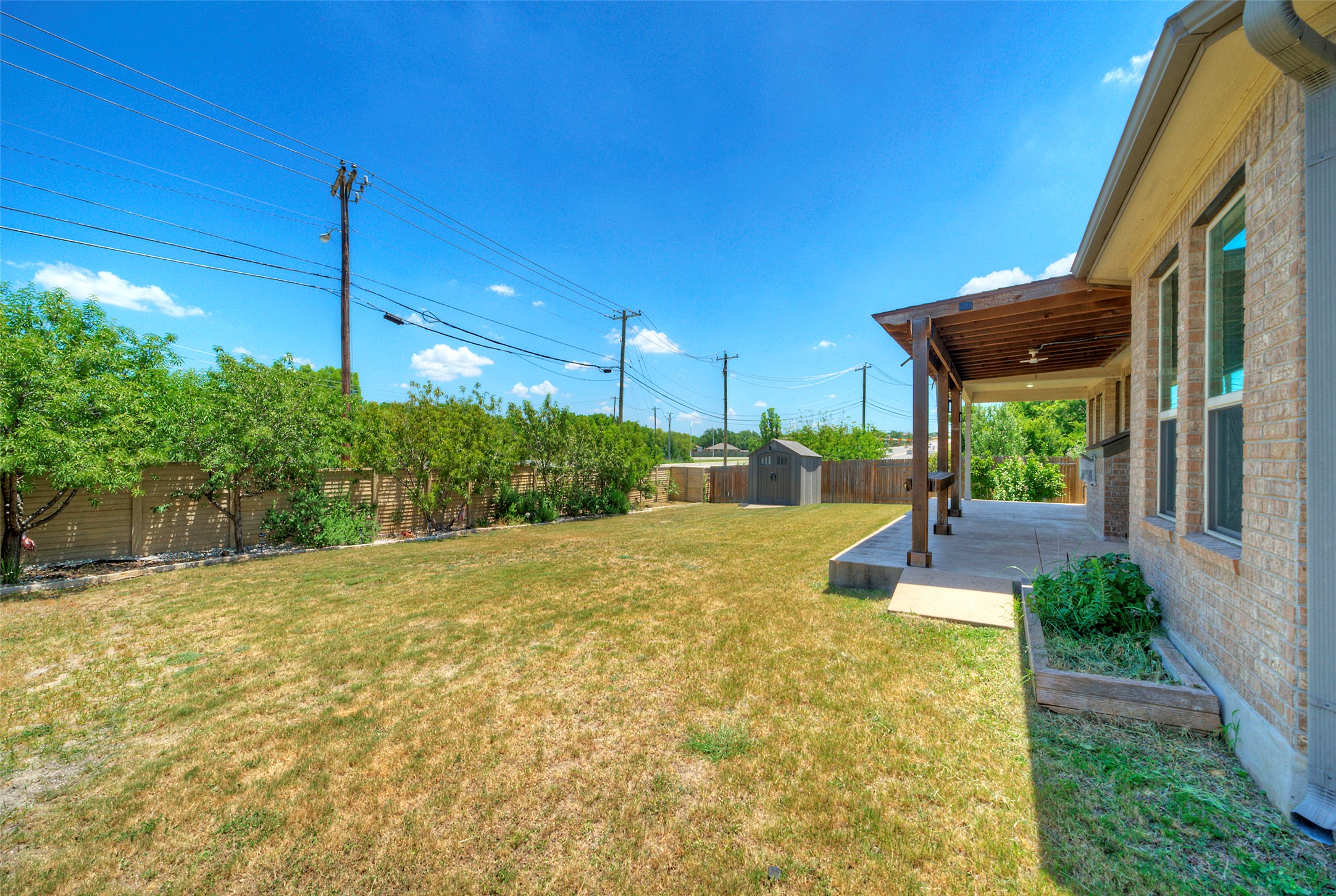 2260 Hat Bender Loop Round Rock, TX 78664 - Photo 39 of 40 A well-maintained yard provides ample space for recreation, complemented by a shaded patio and a storage shed.