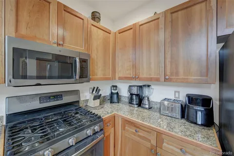 a kitchen with granite countertop a stove sink and cabinets