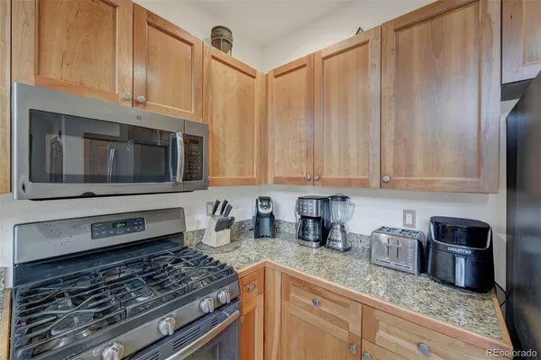 a kitchen with granite countertop a stove sink and cabinets