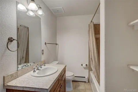 a bathroom with a granite countertop sink toilet and a mirror