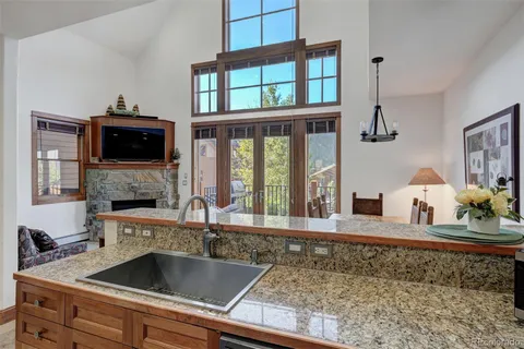 a kitchen with a stove two sinks and a granite counter top