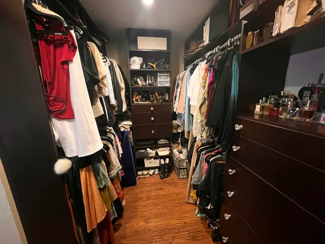 a view of walk in closet with clothes and shoes