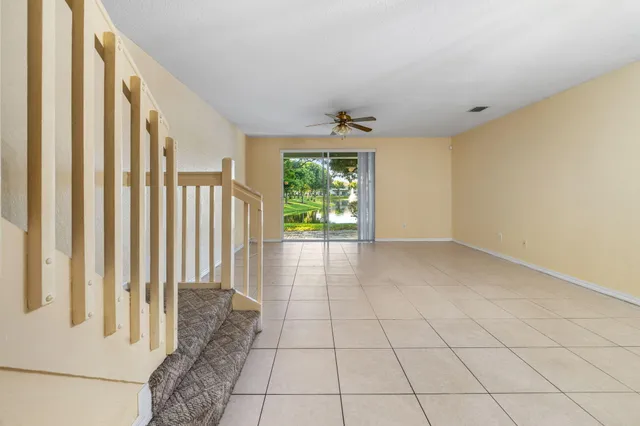 a view of empty room with wooden floor and chandelier
