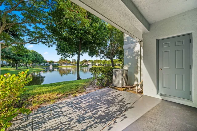 an empty room with chandelier fan and windows