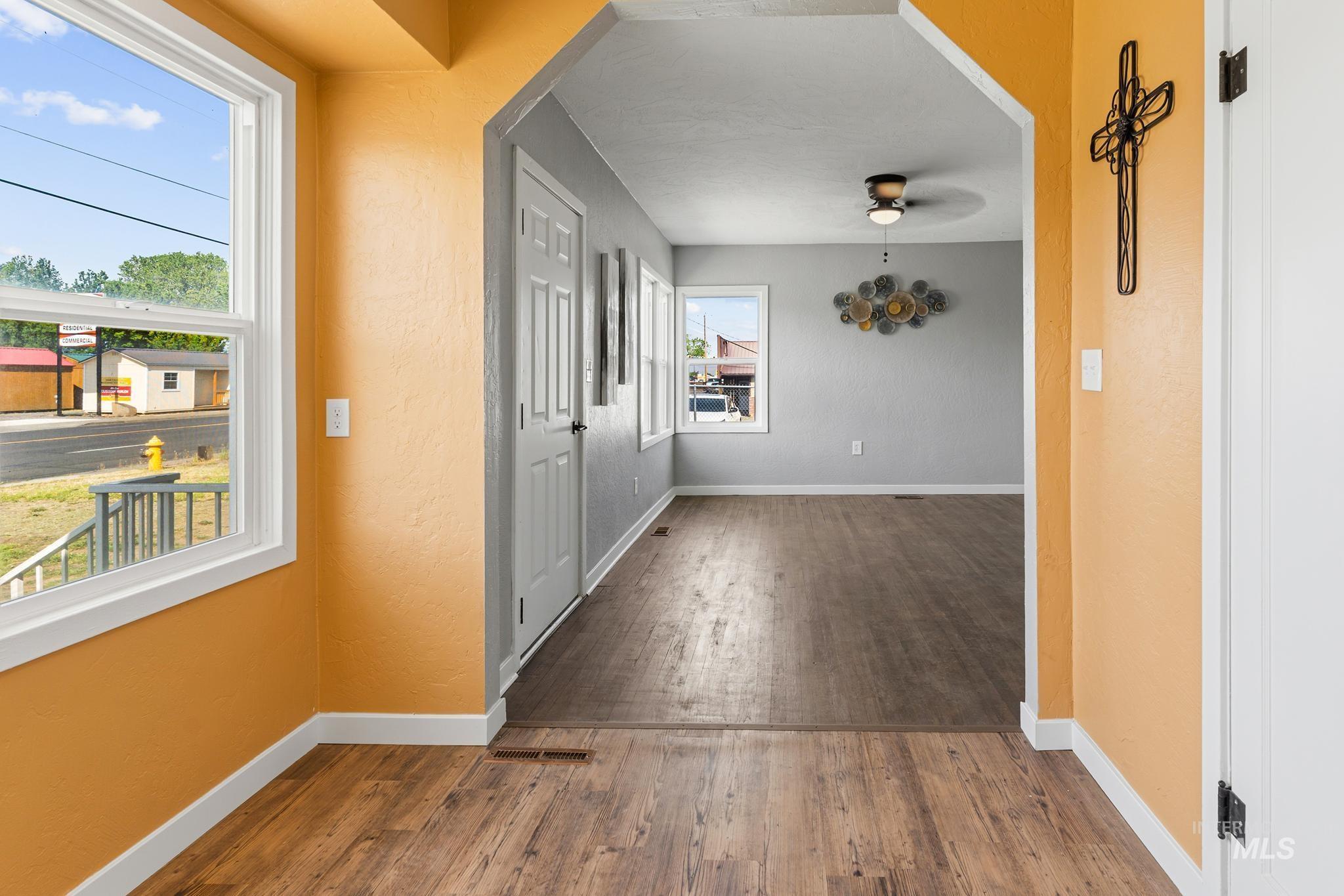 619 Thain Road Lewiston, ID 83501 - Photo 30 of 44 Open interior featuring wood-finish flooring, white trim, and a wide archway connecting two distinct areas