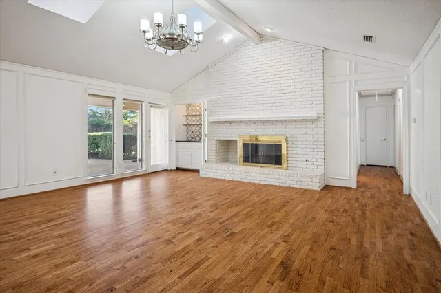 a view of empty room with wooden floor and fireplace