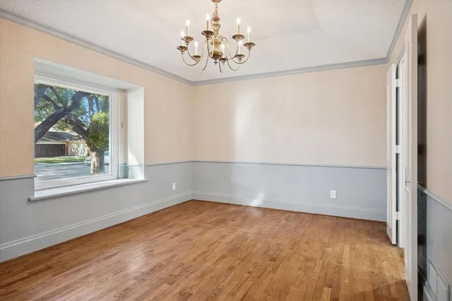 a view of empty room with window and wooden floor