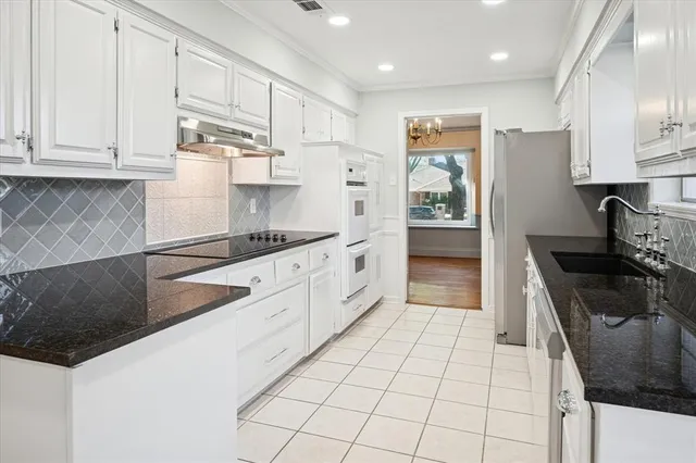 a kitchen with stainless steel appliances a sink stove and cabinets