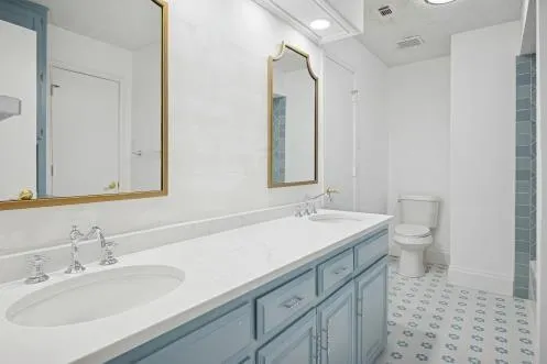 a bathroom with a sink a toilet and a mirror