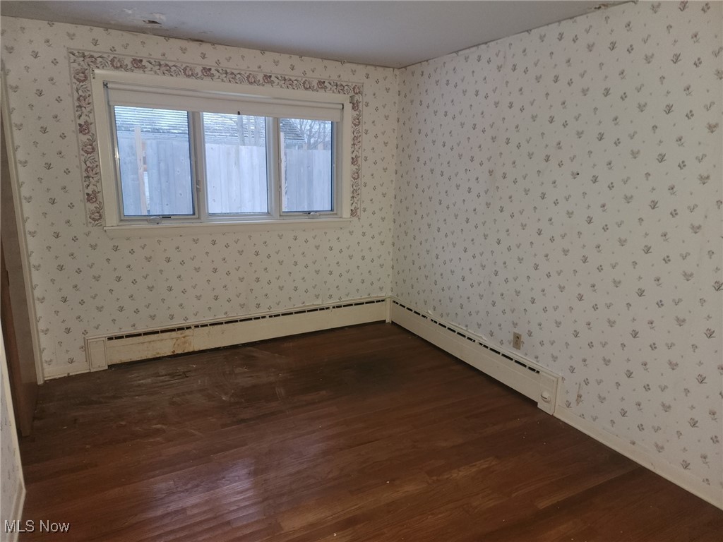 7516 Mayfield Road Chesterland, OH 44026 - Photo 11 of 21 Spare room with dark wood-type flooring and wallpapered walls