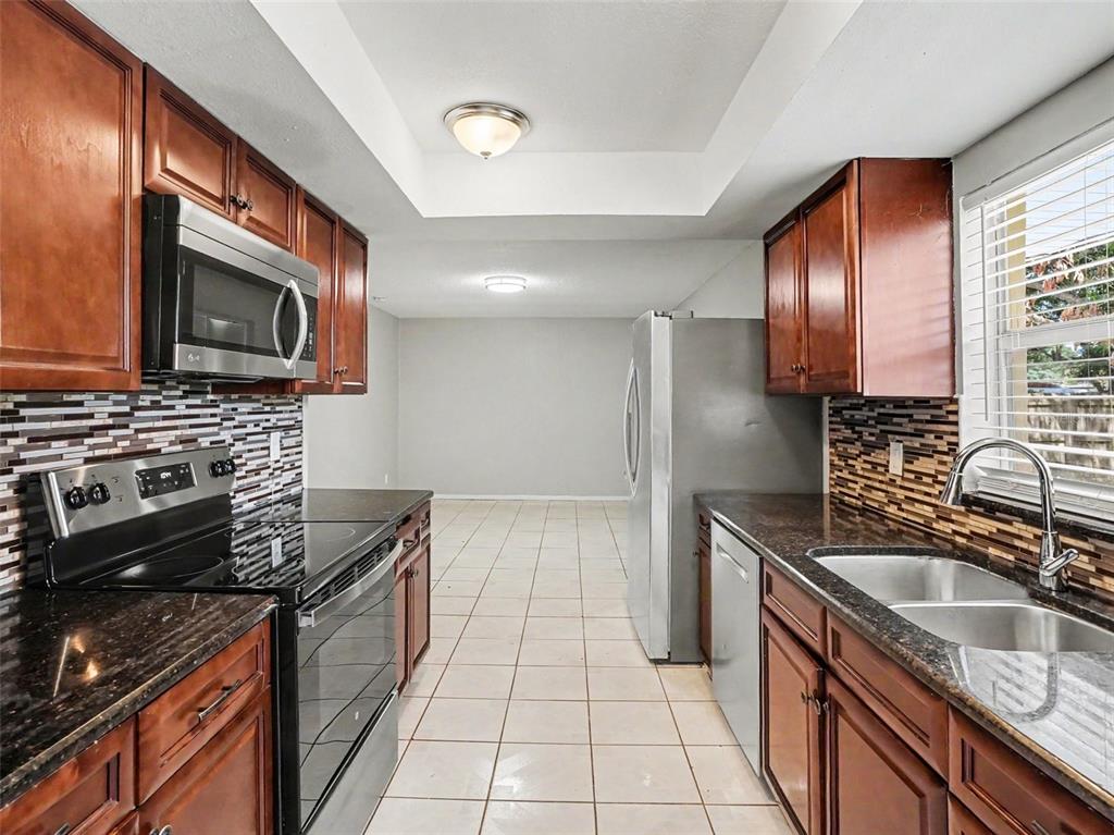 615 Thomas Jefferson Way Orlando, FL 32809 - Photo 4 of 17 a kitchen with stainless steel appliances granite countertop a sink stove and refrigerator