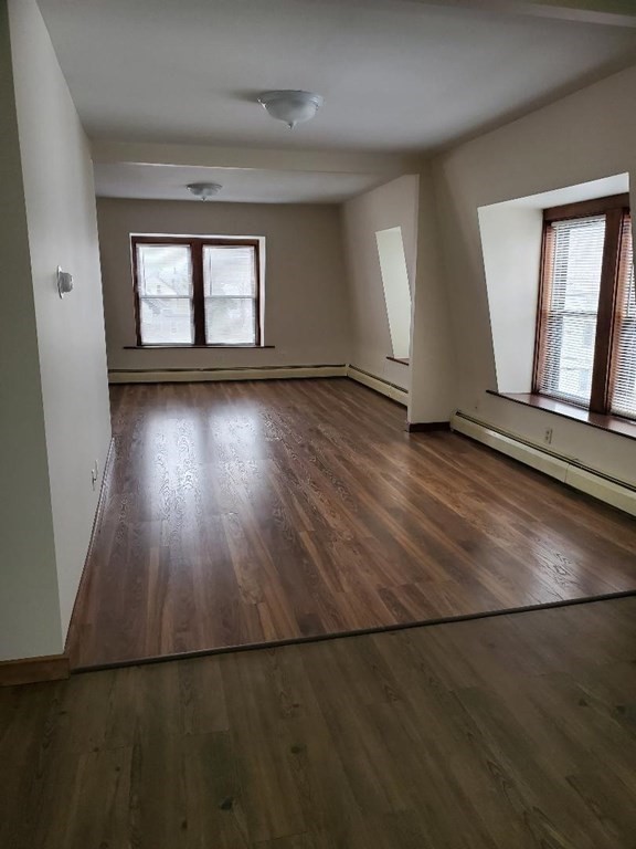 0 Coggeshall Street, Unit 1 Fall River, MA 02721 - Photo 1 of 11 an empty room with wooden floor and windows