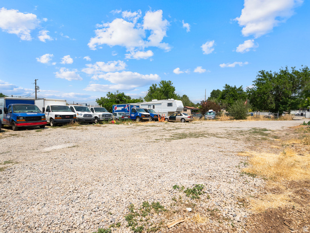 72 Cox Lane Midvale, UT 84047 - Photo 15 of 16 Expansive gravel lot with surrounding mature trees and partial fencing
