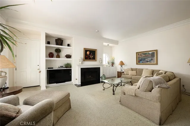 a living room with furniture a fireplace and a large window