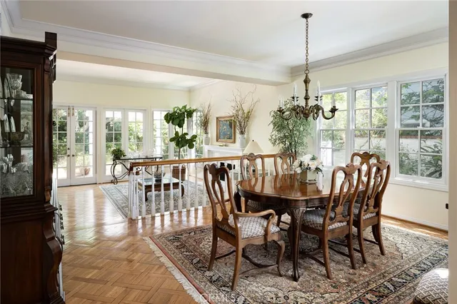 a view of a dining room and livingroom with furniture wooden floor a chandelier