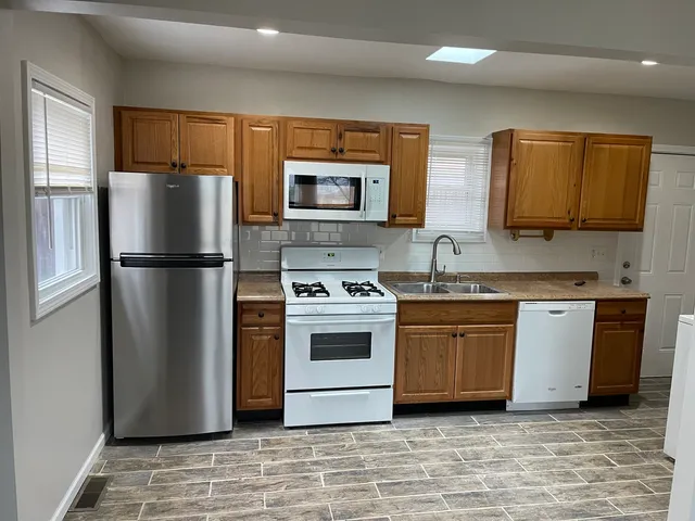 a kitchen with stainless steel appliances granite countertop a refrigerator sink and stove