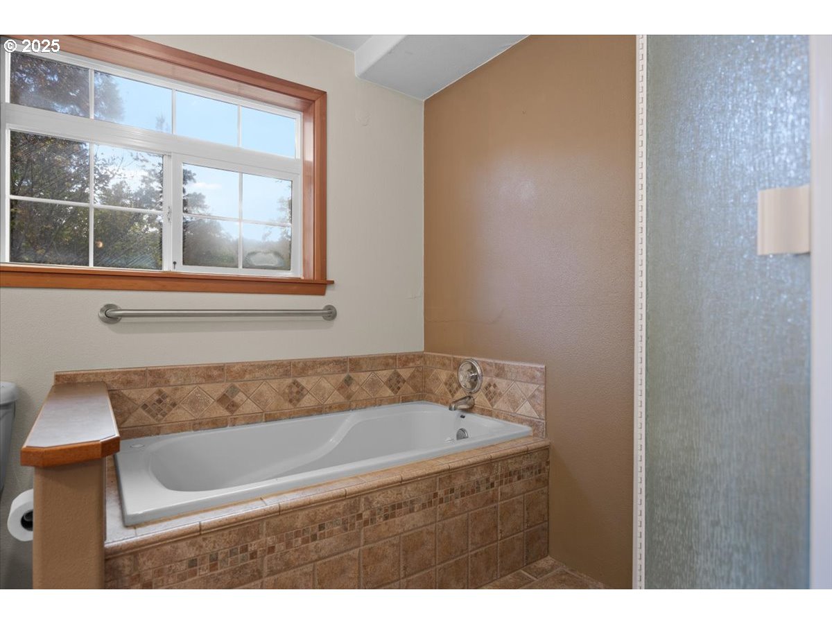 939 Buckhorn Road Roseburg, OR 97470 - Photo 15 of 35 a bathroom with a bathtub and a window
