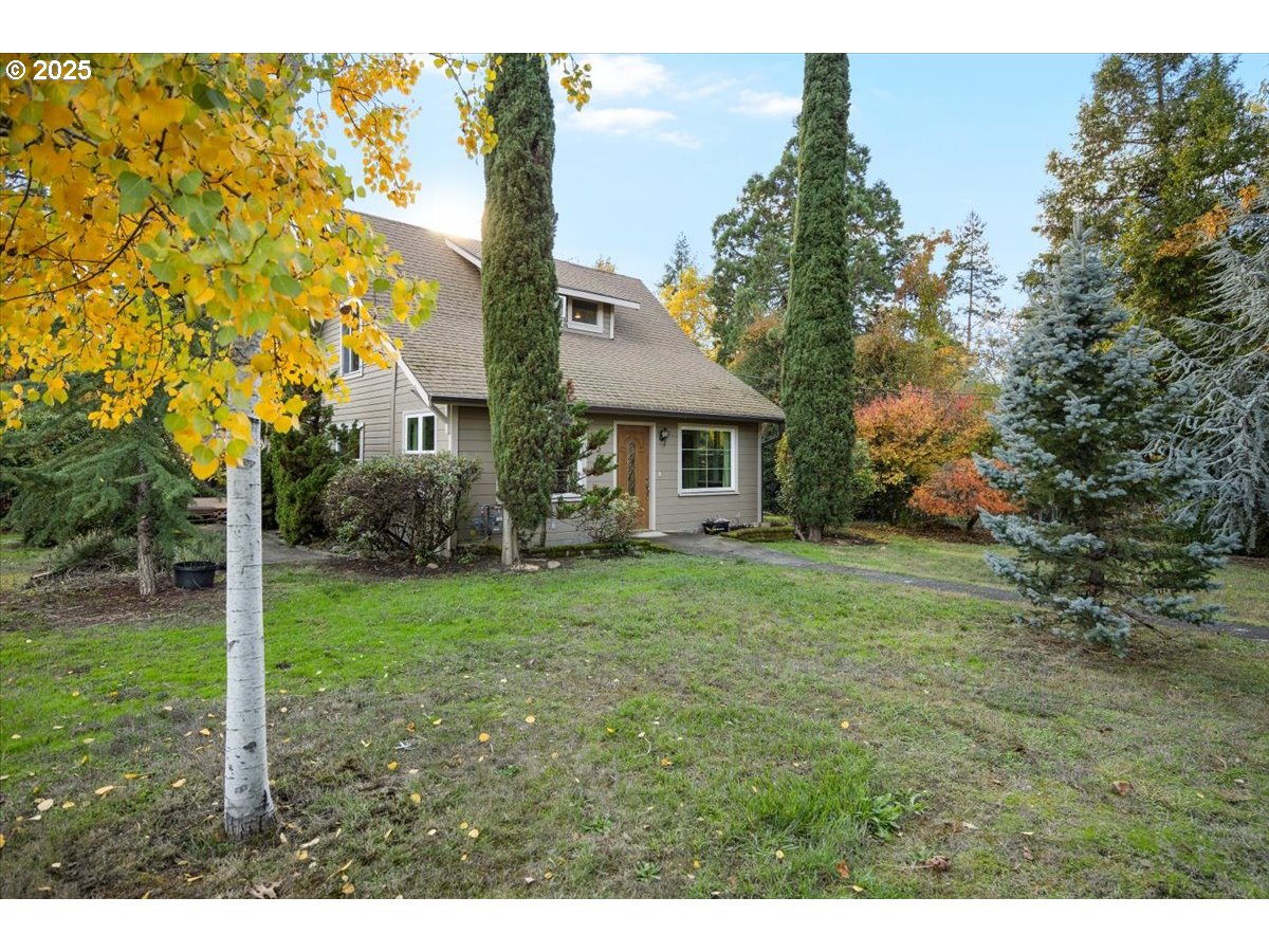 939 Buckhorn Road Roseburg, OR 97470 - Photo 2 of 35 a backyard of a house with plants and large trees