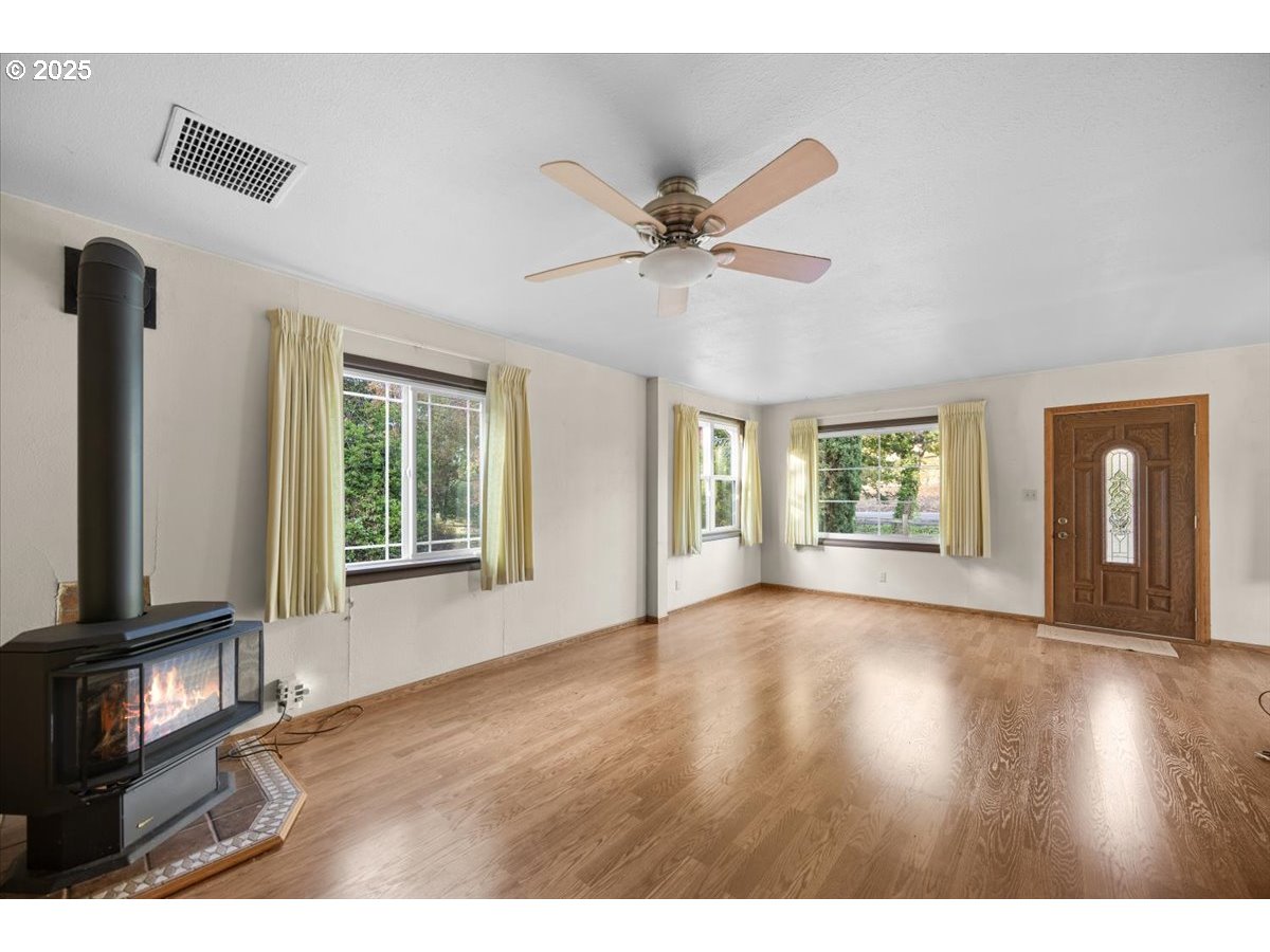 939 Buckhorn Road Roseburg, OR 97470 - Photo 3 of 35 a view of an empty room with a window and wooden floor