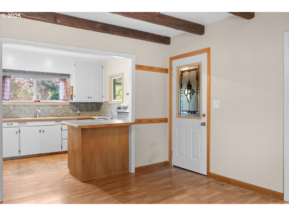939 Buckhorn Road Roseburg, OR 97470 - Photo 8 of 35 a kitchen with granite countertop white cabinets and wooden floor