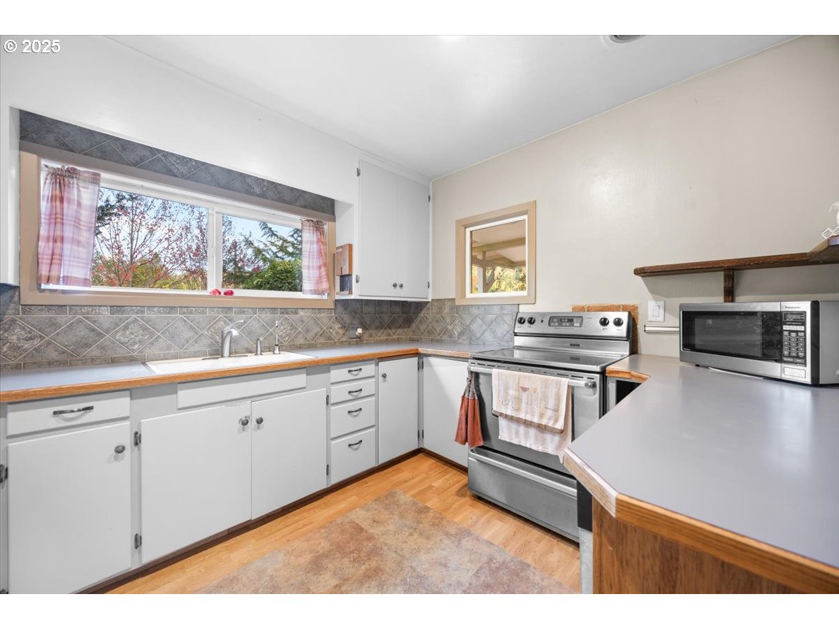 939 Buckhorn Road Roseburg, OR 97470 - Photo 9 of 35 a kitchen with stainless steel appliances granite countertop a stove a sink and a microwave