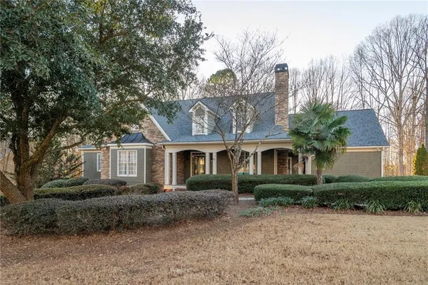 a front view of house with yard and trees around
