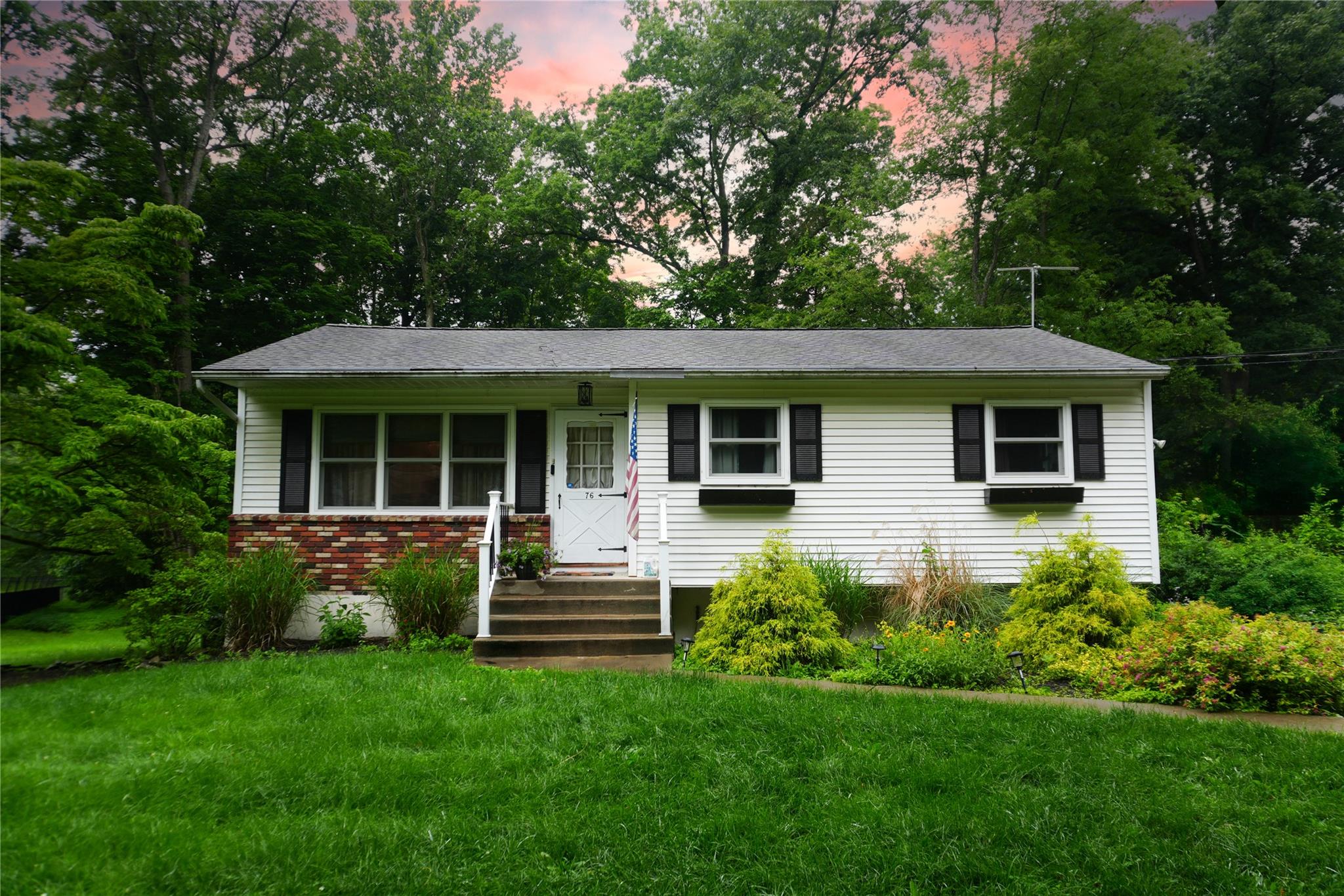 View of front of house featuring a front yard and vinyl siding with brick