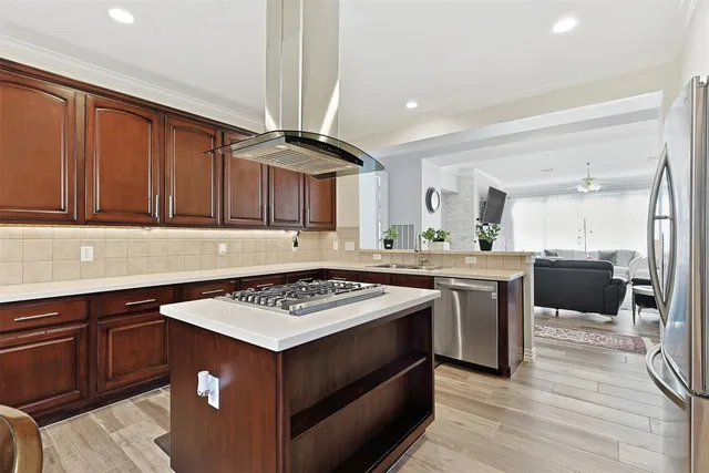 a kitchen with stainless steel appliances a stove a refrigerator and a dining table